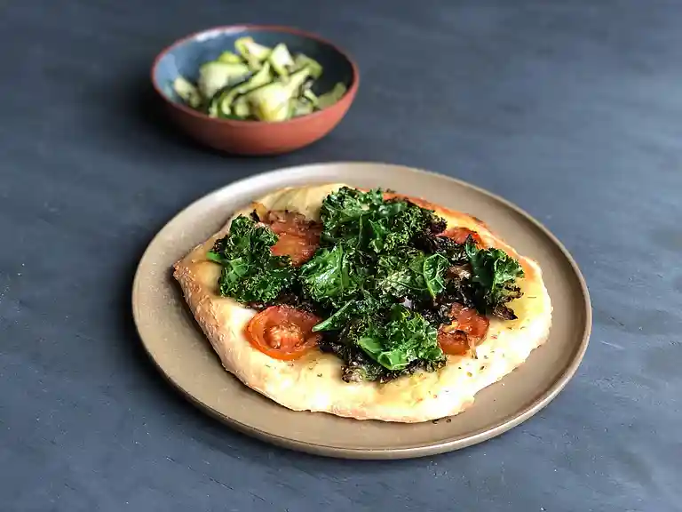 Pizza med karamelliserede løg, grønkål, oregano og squashsalat